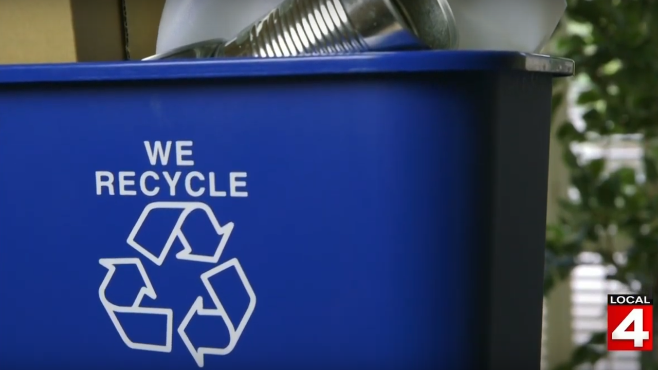 Blue bin that says "we recycle" with recycleable products inside